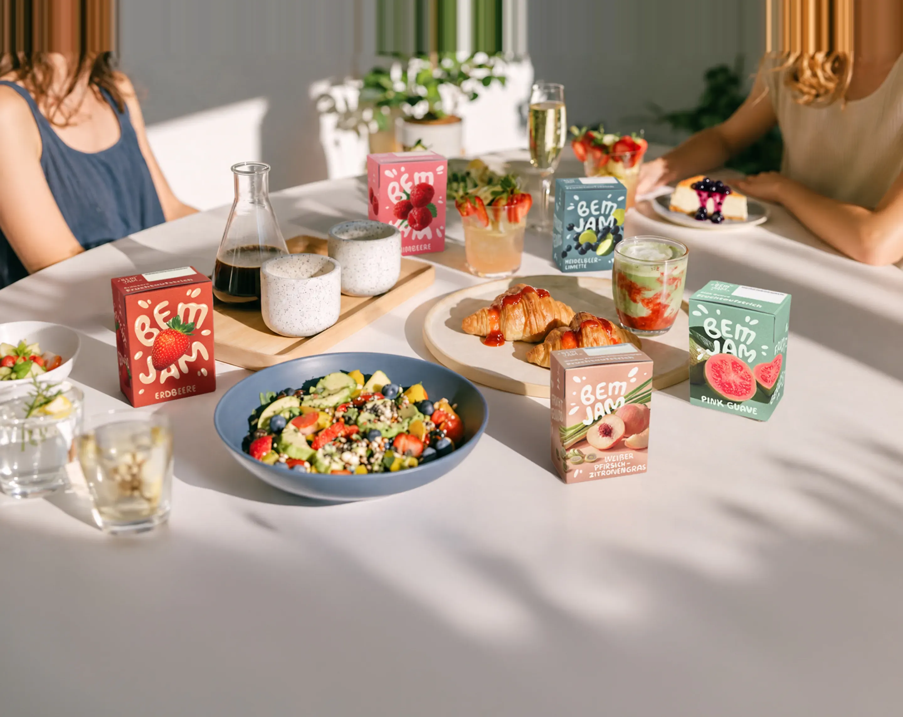 Gedeckter Frühstückstisch mit Bem Jam Packungen, Salat, Croissants und Getränken